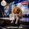Crochet doll with long curly blonde hair wearing a silver outfit, holding a sign reading Emotional Support Queen B.!