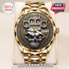 Five Finger Death Punch gold watch with a metallic skull, brass knuckle design, and date window on a display stand.!