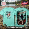 Mint green Friday the 13th t-shirt with Jason Voorhees graphic, lake scenery, and horror movie text on wood surface.!
