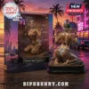 Grand Theft Auto VI mud-covered female figurine in bikini and cap, inside branded display box against sunset beach city.!