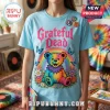 Light blue t-shirt with Grateful Dead text, tie-dye dancing bear, rainbow, and floral butterflies print graphic.!