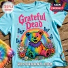 Light blue t-shirt featuring a tie-dye Grateful Dead bear graphic, a rainbow, flowers, butterflies, and pink text.!