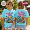 Woman wearing light blue Grateful Dead graphic t-shirt featuring tie-dye bears, rainbows, and flowers in a garden setting.!