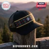 Black trucker hat with multicolored woven pattern and Grateful Dead lightning bolt emblem on a wooden post at sunset.!