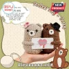 Two crochet bears, one tan with a pink bow and one brown with a black hat, holding a romantic card in a human hand.!