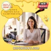 Small crocheted bee amigurumi doll with a sign sitting on an office desk next to a smiling professional woman.!