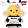 Yellow and black crochet bee doll holding a sign that says Mama Life is sweeter with your love against a white background.!