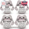 Four grey crochet cats holding white signs with personalized labels like Dad, Aunt, Best Friend, and Bonus Mom.!