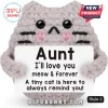 Grey crochet cat amigurumi holding a white sign with black text reading Aunt I love you meow and forever on white background.!