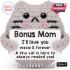 Grey crocheted plush cat holding a sign reading Bonus Mom I'll love you meow and forever with black eyes and pink cheeks.!