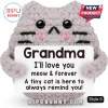 Grey crochet plush cat holding a white sign reading Grandma I'll love you meow and forever with black button eyes.!