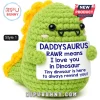 Green crochet dinosaur plushie with yellow spikes holding a sign reading DADDYSAURUS RAWR means I love you in Dinosaur.!