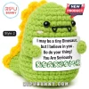 Green crochet dinosaur plush holding a sign that says I may be a tiny Dinosaur, but I believe in you. You Are Seriously ROARSOME.!