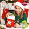 Young girl in Santa hat placing a crochet green dinosaur holding a Best Teacher Ever card into a red stocking.!