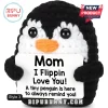 Black and white crocheted penguin plush holding a white sign reading Mom I Flippin Love You on a plain white background.!