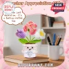 Crochet potted flower desk accessory with purple, pink, and white blooms holding a sign that says Never Forget The Difference.!