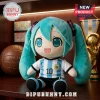 Plush Hatsune Miku figure wearing an Argentina national soccer jersey with number 10, positioned on a wooden shelf.!