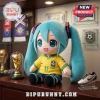 Hatsune Miku plush toy wearing a yellow Brazil national soccer team jersey with number 11 on a wooden desk.!