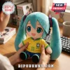 Hatsune Miku plush toy wearing a yellow Brazil soccer jersey with number 11, held by hands on a wooden desk.!