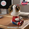 White cat plush doll with dreadlocks wearing a red and blue soccer jersey and holding a patterned soccer ball on a desk.!
