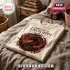 House of the Dragon graphic cream t-shirt with dragon head, crown, and Fire Remembers Blood text on a rumpled bed.!