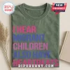 Human Rights Migrant Children Heartbeats T-Shirt in olive green with pink and blue text on a neutral background.