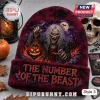 Iron Maiden Halloween Beanie Hat 2026 featuring Eddie the Head holding a glowing jack-o'-lantern on dark maroon fabric.