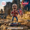 Iron Maiden The Trooper Eddie figurine holding a tattered British flag on a circular base over a rocky terrain background.!