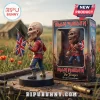 Iron Maiden The Trooper vinyl figure holding a British flag next to its branded display box on a wooden plank surface.!