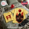 Yellow t-shirts featuring Pennywise from the movie IT with a red balloon, graphic prints, and splatter patterns on a bed.!