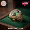 Gold championship ring with a large emerald green stone, tennis racket logo, and embedded crystals in a velvet box.!