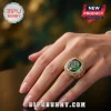 Gold championship ring featuring a central green stone and tennis racket emblem worn on a hand.!