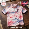 Pink and white Japan soccer polo shirt with cherry blossom print, mountains, national flag, and eagle crest emblem.!