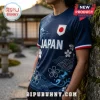 Dark blue Japan soccer jersey with white wave patterns, cherry blossom graphics, and a Japanese flag patch on the chest.!