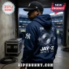 Man wearing a navy blue hoodie with a white turntable graphic, New York Yankees logo, and Jay-Z 2026 tour print on back.!