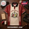 Kappa Alpha Psi Embroidered Crest Polo Shirt in cream and crimson featuring fraternity symbols on a wooden background.