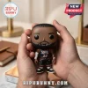 LeBron James Philadelphia 76ers Funko Pop vinyl figure held in two hands against a blurred office desk background.