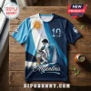 Argentina football jersey with Sun of May graphic, player silhouette, number 10, and world trophy on a wooden table.!