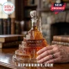 Minas Tirith shaped glass decanter containing amber liquid with a white crown stopper on a wooden desk background.!
