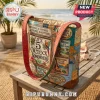 Margaritaville It’s 5 O’Clock Somewhere quilted tote bag with tropical graphics and orange straps on a wooden patio table.