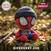 Marvel Spider-Man Winter Beanie Plush Toy wearing a gray knit cap and striped scarf while sitting on a tree stump.