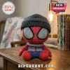 Marvel Spider-Man Winter Beanie Plush Toy wearing a grey knitted cap, holographic eyes, and a puffer vest on a desk.