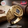 Masonic gold plated square and compasses ring featuring a blue G symbol and embossed pillar designs on a wooden table.