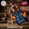 Metallica branded glass guitar shaped whiskey bottle with blue lightning pattern and cork stopper on a wooden table.!