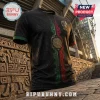 Black Mexico soccer jersey featuring an Aztec sun stone graphic with green and red geometric trim against stone ruins.!