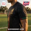 Black soccer jersey featuring an embroidered Mexico eagle emblem and green and red vertical detailing on a grassy field.!