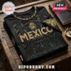 Black t-shirt with gold Mexico text, Aztec calendar patterns, and an eagle emblem resting on a wooden surface.!