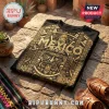 Black cotton t-shirt featuring a gold foil Aztec calendar print and the word MEXICO on a stone patio surface.!