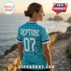 Woman wearing a teal jersey with Neptune and 07 printed on the back, featuring geometric patterns against a coastal view.!