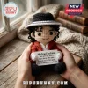 Amigurumi Michael Jackson doll wearing a black fedora and red jacket, holding a card with lyrical text.!